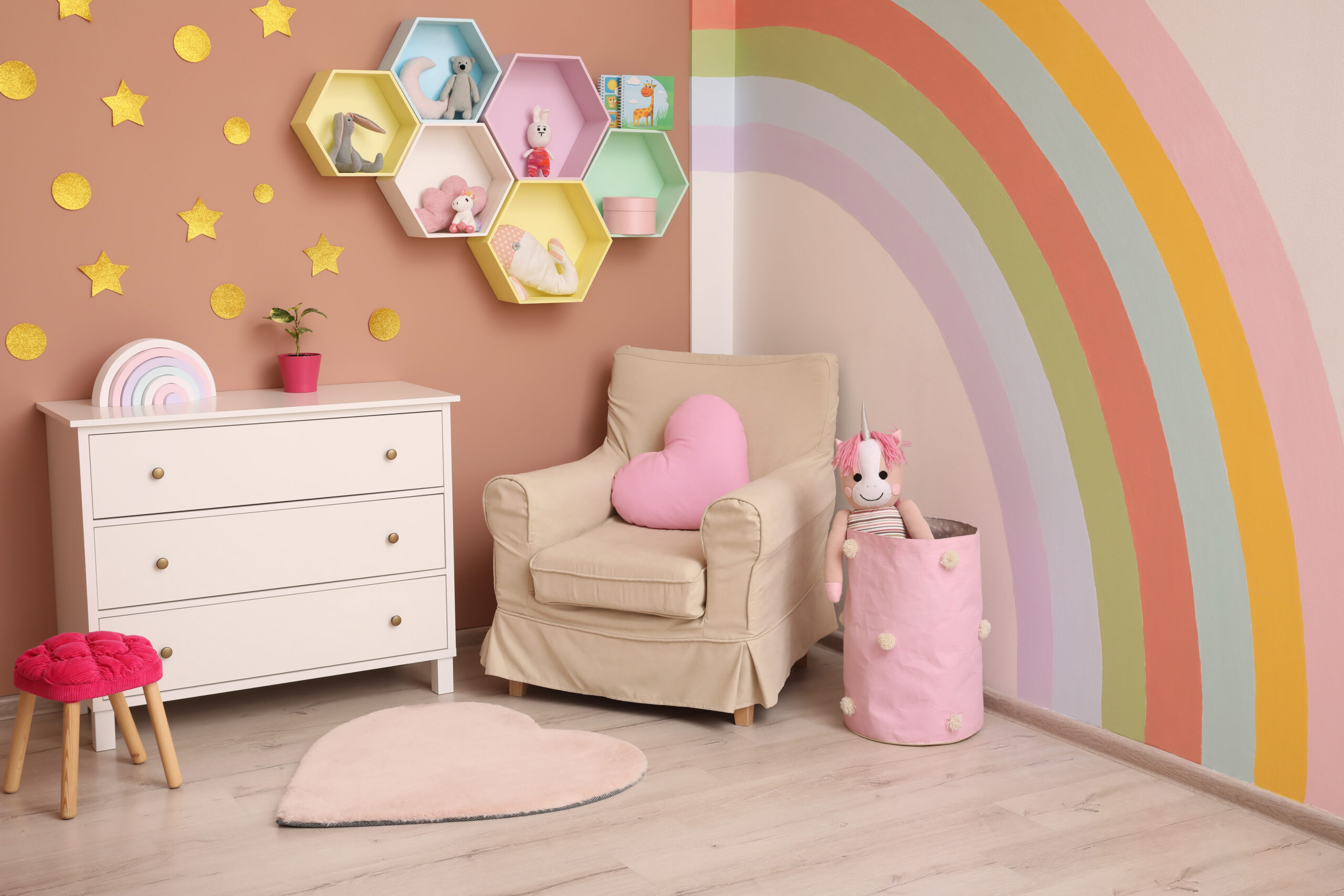 Cute child’s room interior with beautiful rainbow painted on wall