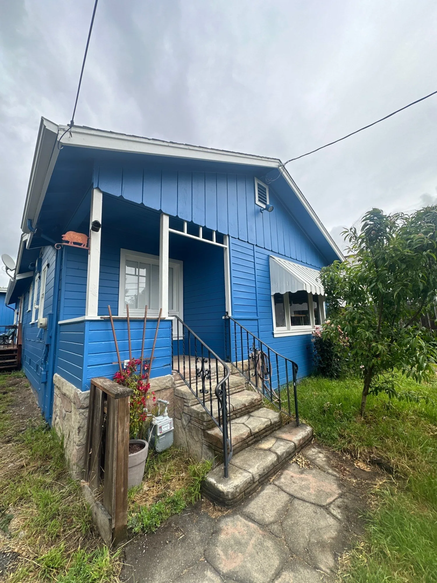Bright Blue Exterior House Painting Bright blue exterior residential house with white trim and metal railings after painting in Danville area