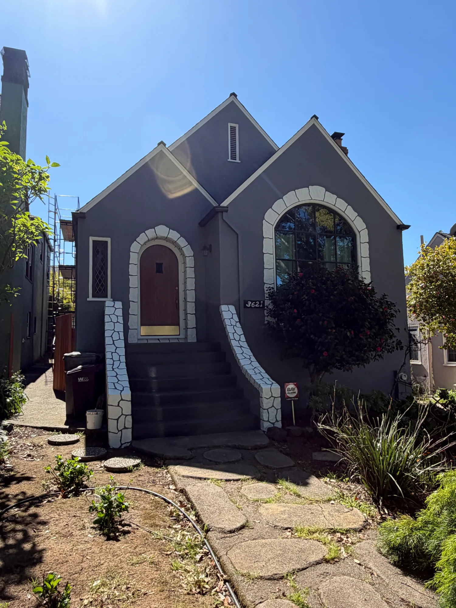 Charcoal Gray Residential Exterior Charcoal gray residential home with white stone trim around arched doorway and window in Danville area